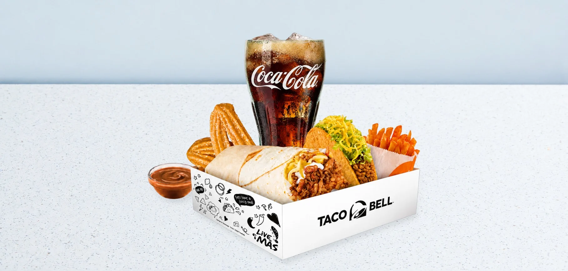 3405-crunchwrap-deluxe-box | Taco Bell Hrvatska Taco Bell combo box with burrito, taco, fries, and a tall Coca‑Cola cup on a light speckled table.